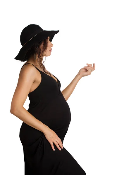 Μια Όμορφη Έγκυος Γυναίκα Μαύρο Φόρεμα Και Καπέλο Απομονωμένη Λευκό — Φωτογραφία Αρχείου