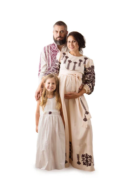 白い背景に隔離された伝統的な民族衣装の中で妊娠中の母親 父と娘のウクライナの家族 — ストック写真