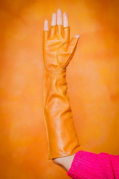Gul Lång Vante Handskar Kvinnas Hand Orange Bakgrund — Stockfoto