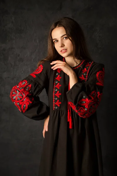 美しいですウクライナの女性で黒刺繍ドレス上の暗い背景 — ストック写真