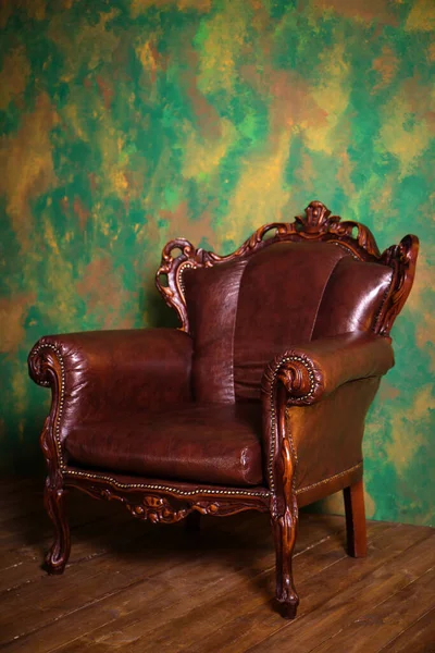 Piękny Zabytkowy Skórzany Fotel Drewnianymi Detalami Zielonym Tle Ściany — Zdjęcie stockowe