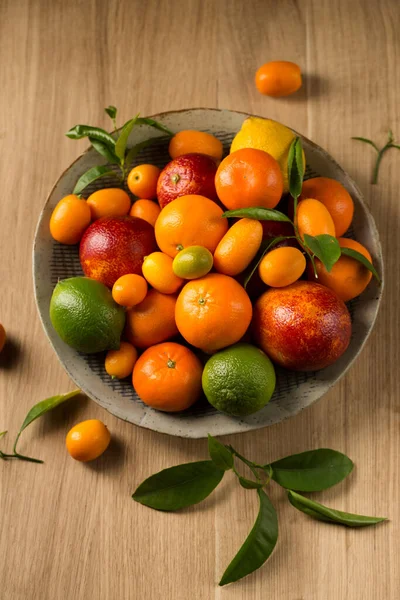 木桌上有一大盘多汁的柑橘类水果 — 图库照片