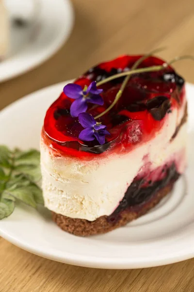 Een Ongelooflijk Romig Dessert Met Bessengelei Violette Bloemen Een Wit — Stockfoto