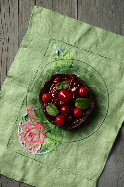 带有樱桃和薄荷的巧克力甜点在勃艮第背景的盘子里 — 图库照片