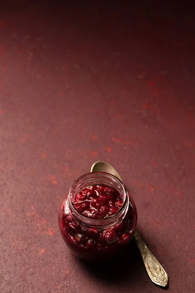 Pyszny Sos Lingonberry Małym Szklanym Słoiku Burgundowym Tle — Zdjęcie stockowe