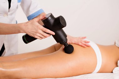 Masaj terapisti hastaya lenfatik drenaj ve kalçasında masaj aleti olan anti-selülit masajı yapar.