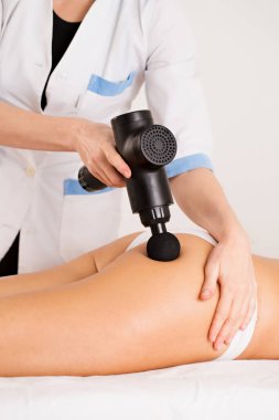 Masaj terapisti hastaya lenfatik drenaj ve kalçasında masaj aleti olan anti-selülit masajı yapar.