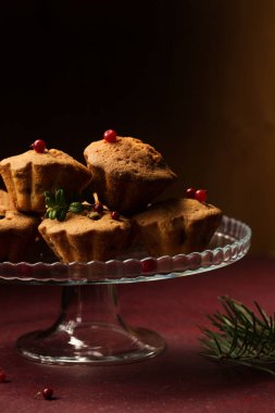 Koyu bir arka planda cam tatlı standında yaban mersinli kırmızı kekler.