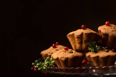 Koyu bir arka planda cam tatlı standında yaban mersinli kırmızı kekler.