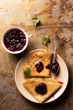 Grunge metal arka planda kuşüzümü reçelli kızarmış krep.