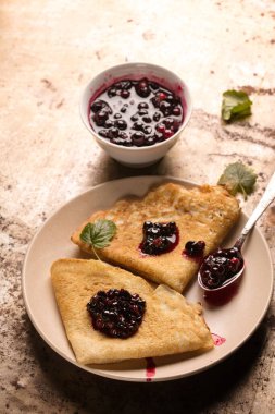 Grunge metal arka planda kuşüzümü reçelli kızarmış krep.