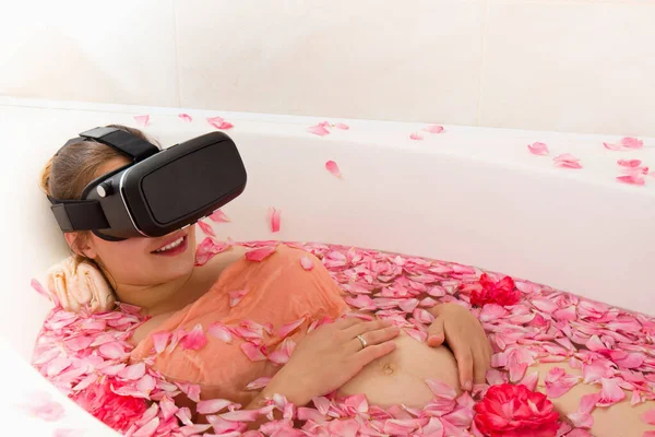 Μια Έγκυος Γυναίκα Γυαλιά Εικονικής Πραγματικότητας Στηρίζεται Ένα Μπάνιο Ροδοπέταλα Εικόνα Αρχείου