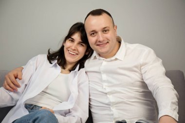 Portrait of a cheerful young couple in white shirts