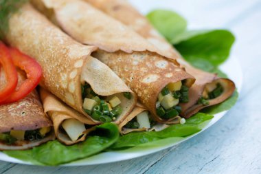 Ahşap arka planda taze soğan ve yumurta ile lezzetli krep.