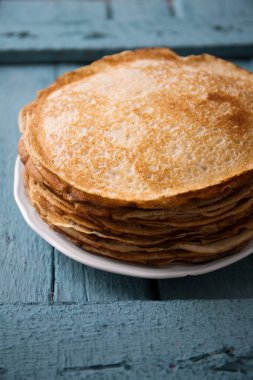 Ahşap bir arka planda tabakta lezzetli, ince krep.