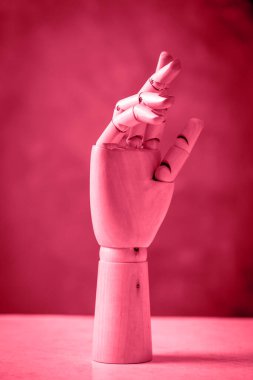 Mannequin hands made of wood on a pinkbackground
