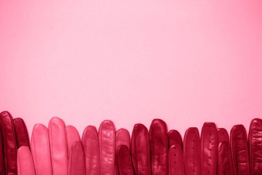 Pembe arka planda bir sürü parlak renkli eldiven