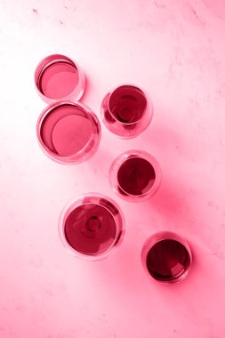 Red wine in different glasses on a white background, top view