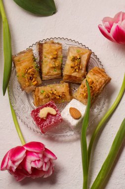 Pembe laleli hafif bir arka planda doğulu tatlılarla dolu bir hayat