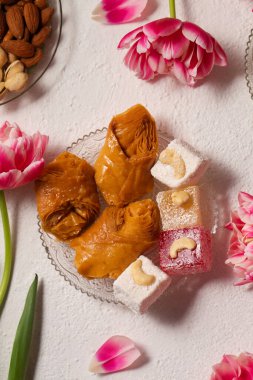 Pembe laleli hafif bir arka planda doğulu tatlılarla dolu bir hayat