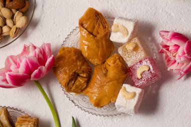 Pembe laleli hafif bir arka planda doğulu tatlılarla dolu bir hayat