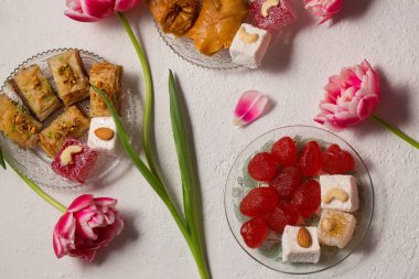 Pembe laleli hafif bir arka planda doğulu tatlılarla dolu bir hayat