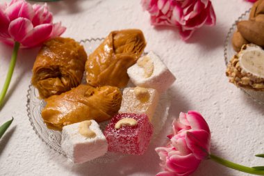 Pembe laleli hafif bir arka planda doğulu tatlılarla dolu bir hayat