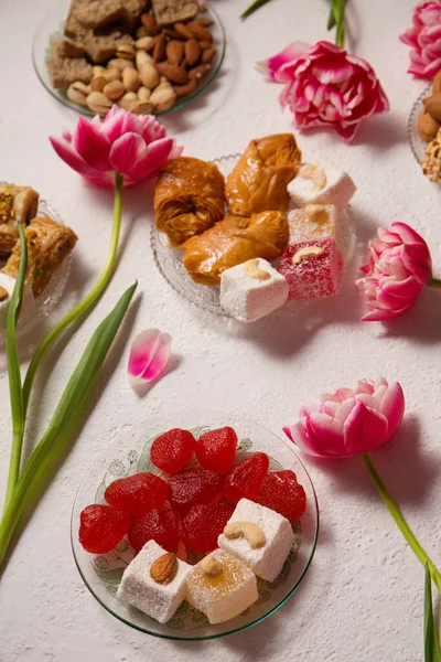 Pembe laleli hafif bir arka planda doğulu tatlılarla dolu bir hayat