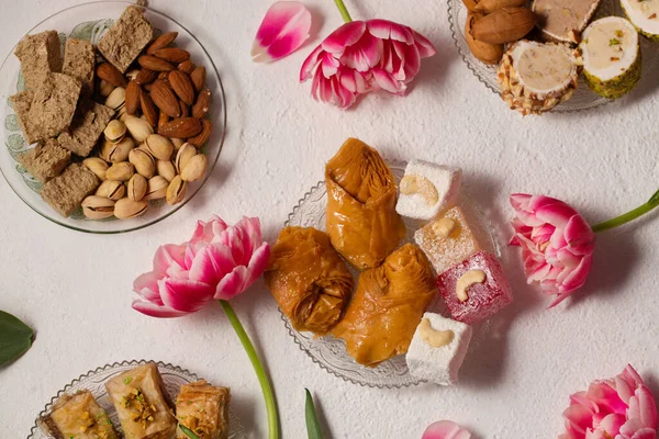 Pembe laleli hafif bir arka planda doğulu tatlılarla dolu bir hayat