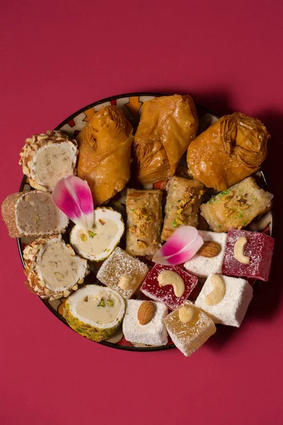 stock image Still life of oriental sweets on a pink background with pink tulip