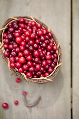 Ahşap bir arka planda ahşap bir sepetin içinde ekşi böğürtlen