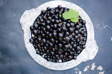 Ahşap bir arka planda eski metal tepside olgun siyah üzümler..