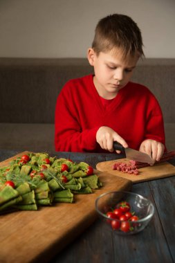 Noel yemeği panosu. Domates ve sosisle süslenmiş ıspanaklı krepten yapılmış Noel ağacı..