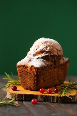 Biberiye ve böğürtlenlerle süslenmiş pudra şekerli lezzetli Noel keki.