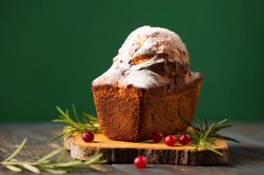 Biberiye ve böğürtlenlerle süslenmiş pudra şekerli lezzetli Noel keki.