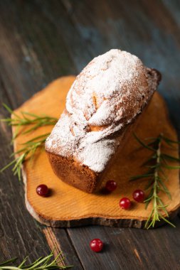 Biberiye ve böğürtlenlerle süslenmiş pudra şekerli lezzetli Noel keki.