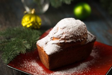Biberiye ve böğürtlenlerle süslenmiş pudra şekerli lezzetli Noel keki.