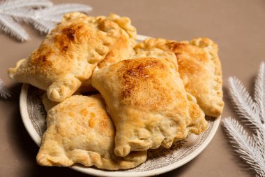 Noel ağacı dallarıyla süslenmiş elmalı ev yapımı turtalar.