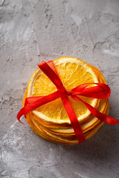 Dry candied orange slices on a gray textured background