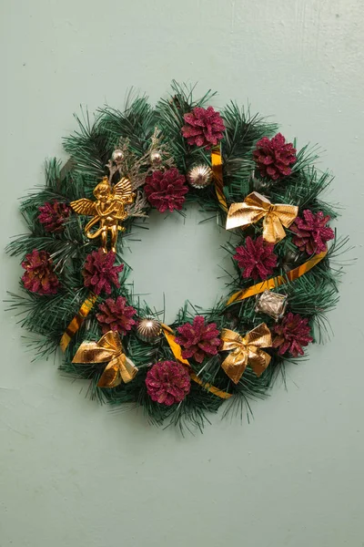 Christmas wreath with pine cones and golden bows in vintage style on a gray background