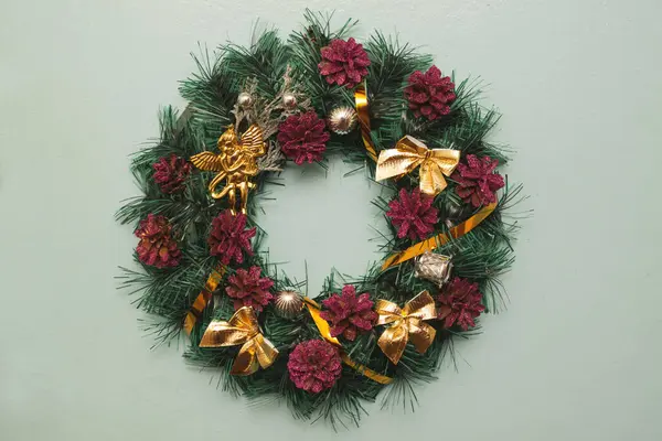 Christmas wreath with pine cones and golden bows in vintage style on a gray background