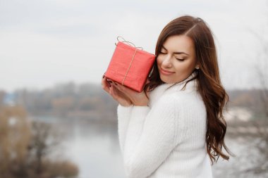 Genç bir kadın elinde kırmızı bir kutu tutuyor. Sevgililer Günü konsepti