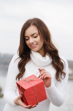 Genç bir kadın elinde kırmızı bir kutu tutuyor. Sevgililer Günü konsepti
