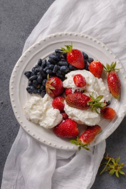 Çilekli süt tatlısı ve gri arka planda hanımeli.