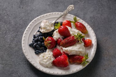 Çilekli süt tatlısı ve gri arka planda hanımeli.