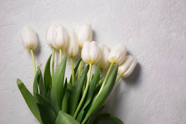 Açık arkaplanda bir buket güzel beyaz lale.