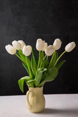 Sarı sürahide güzel beyaz laleler.