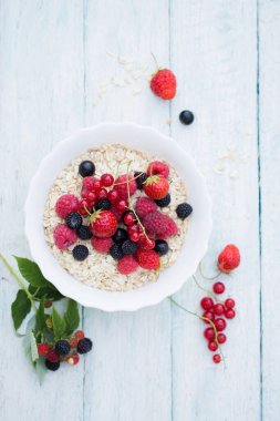 Beyaz kasede yulaf ezmesi ve böğürtlen
