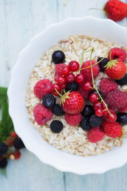 Beyaz kasede yulaf ezmesi ve böğürtlen