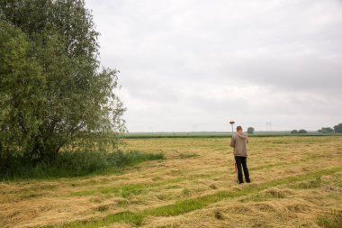 Erkek bir araştırmacı açık alanda bir GNSS alıcısıyla çalışıyor.